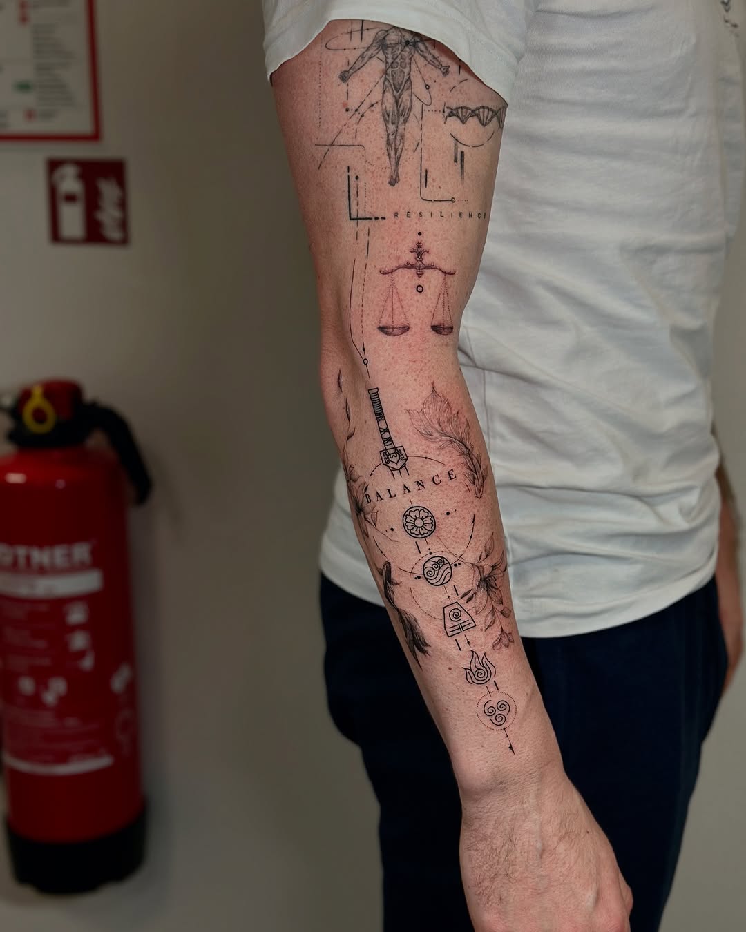 Intricate balance-themed forearm tattoo design