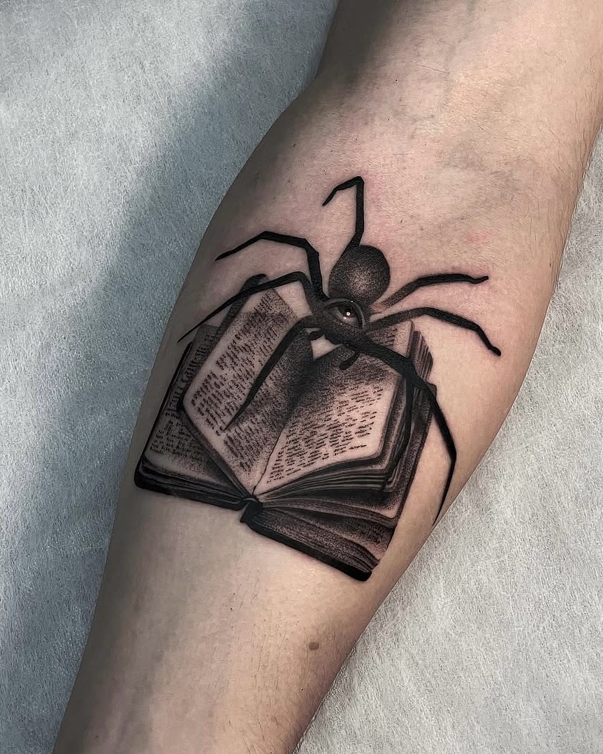 Unique forearm tattoo of spider and book.