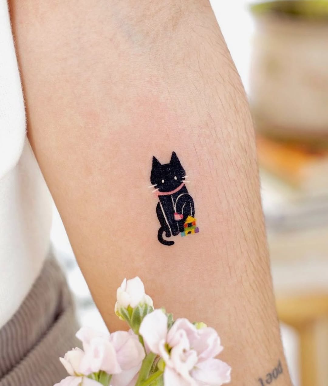 Charming black cat tattoo with vibrant colors