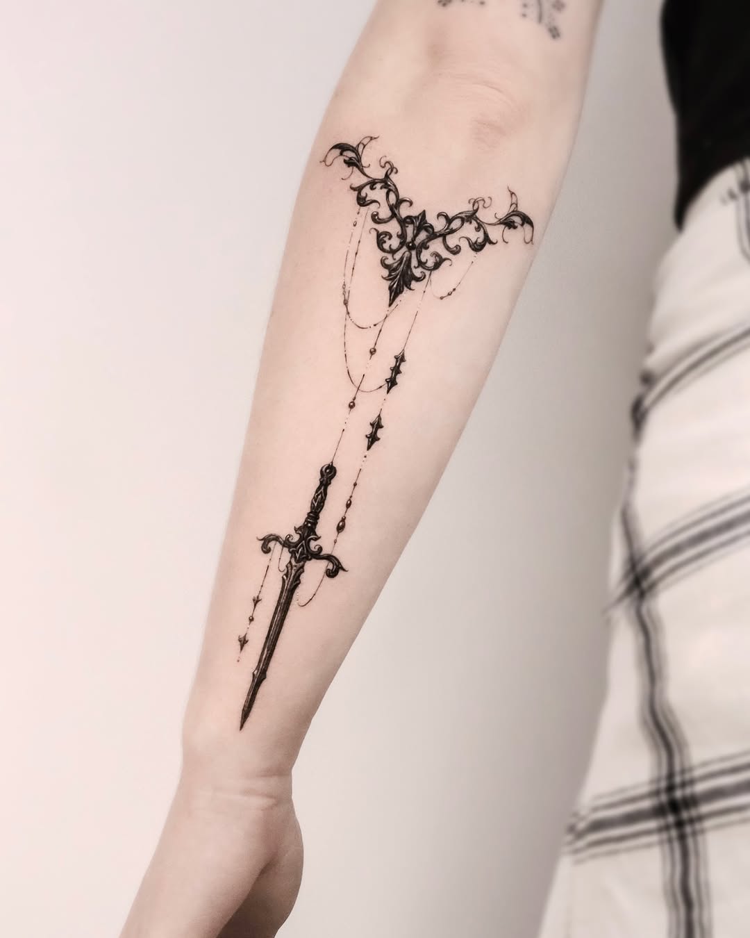 Intricate Floral Sword Tattoo on Forearm