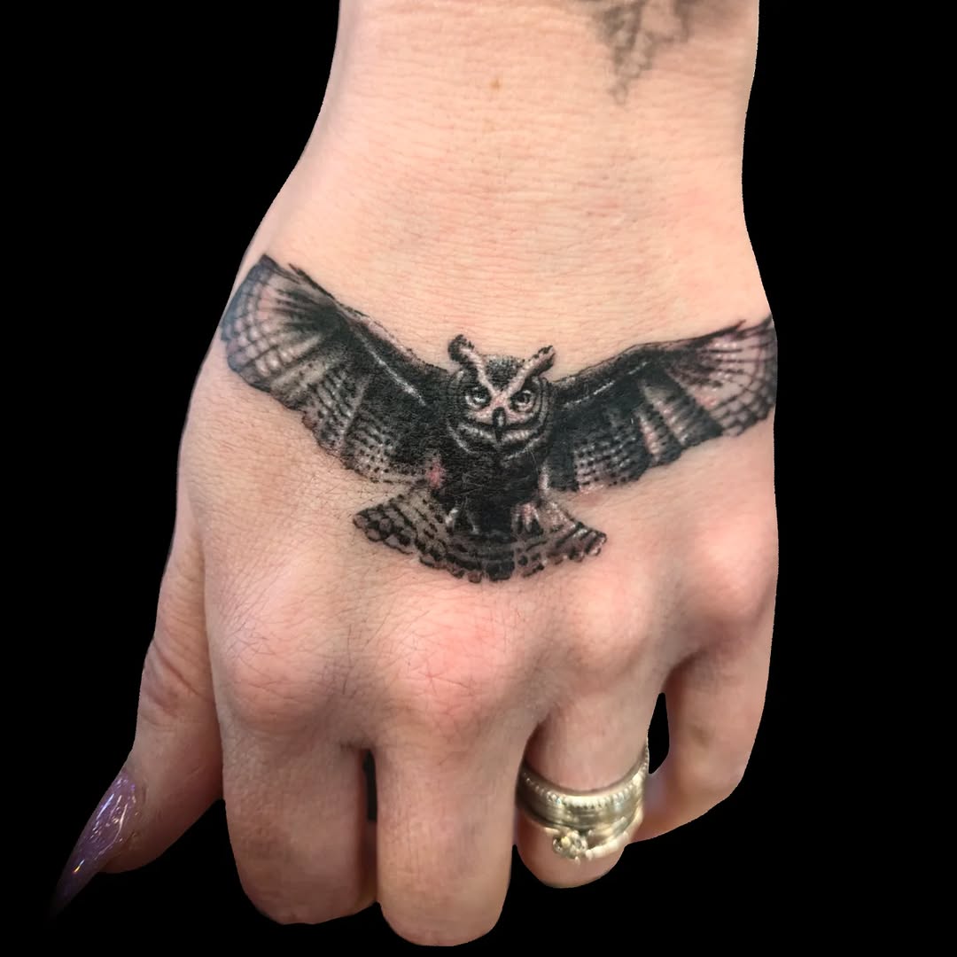 Striking owl tattoo in flight on hand
