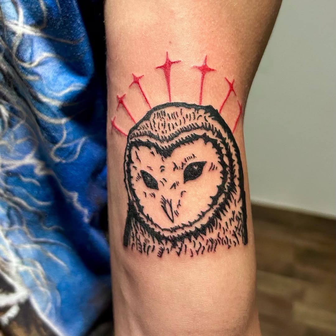 Minimalistic owl tattoo with vibrant star accents