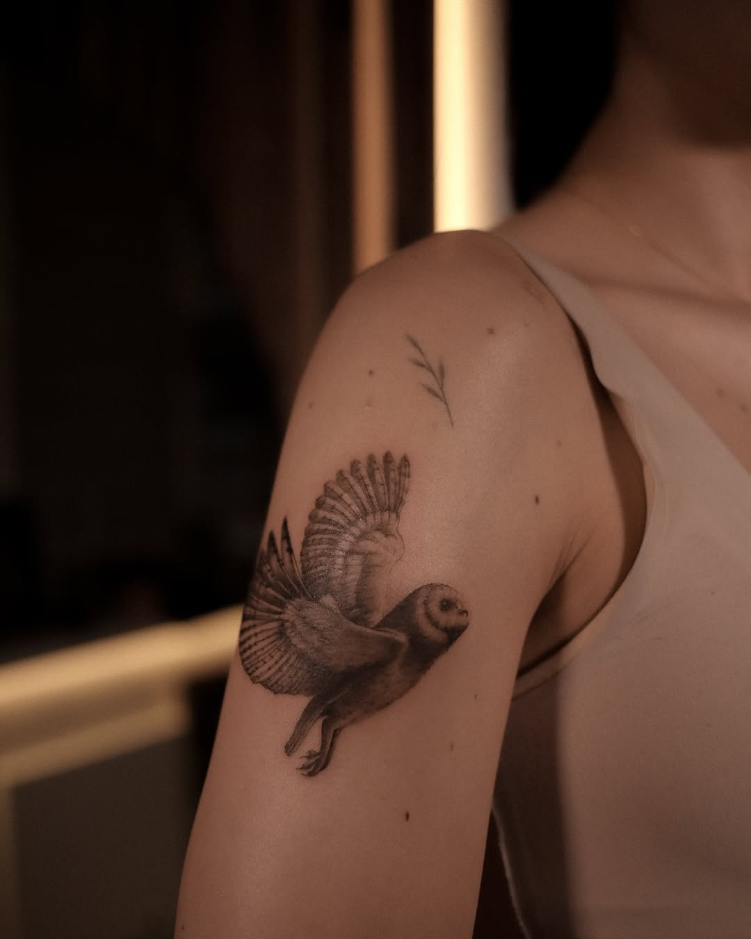 Elegant flying owl tattoo on the arm