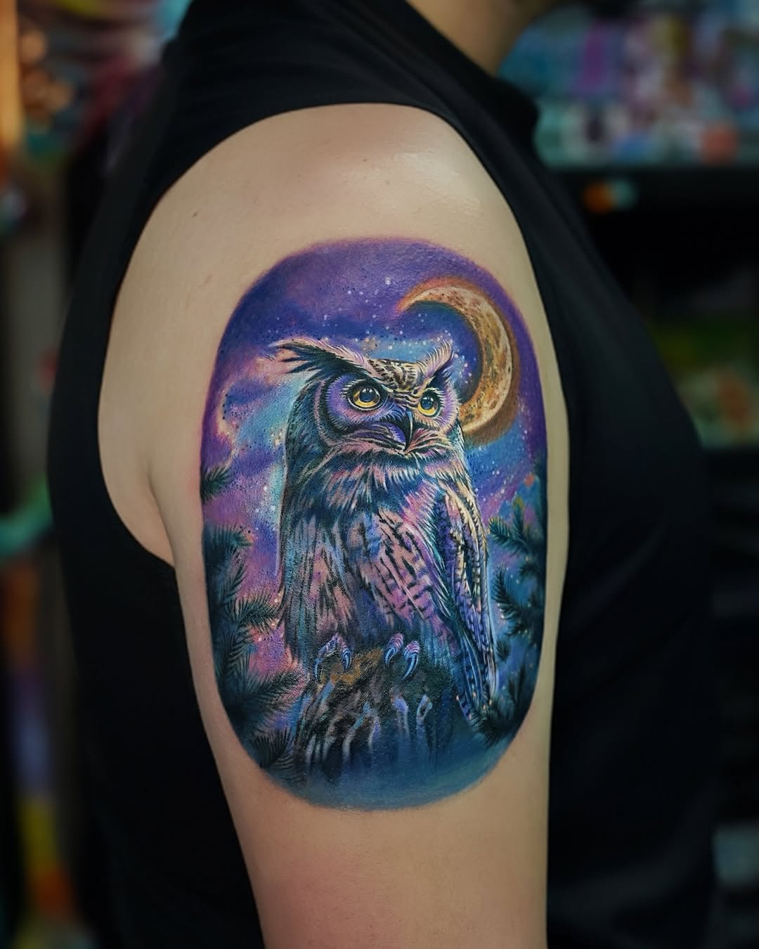 Vibrant owl tattoo against a cosmic backdrop