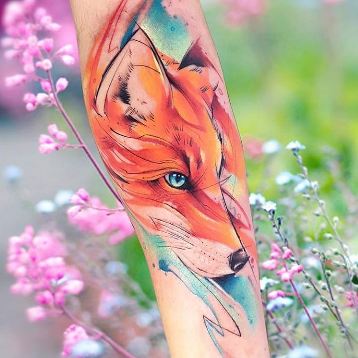 Vivid watercolor fox design on the forearm