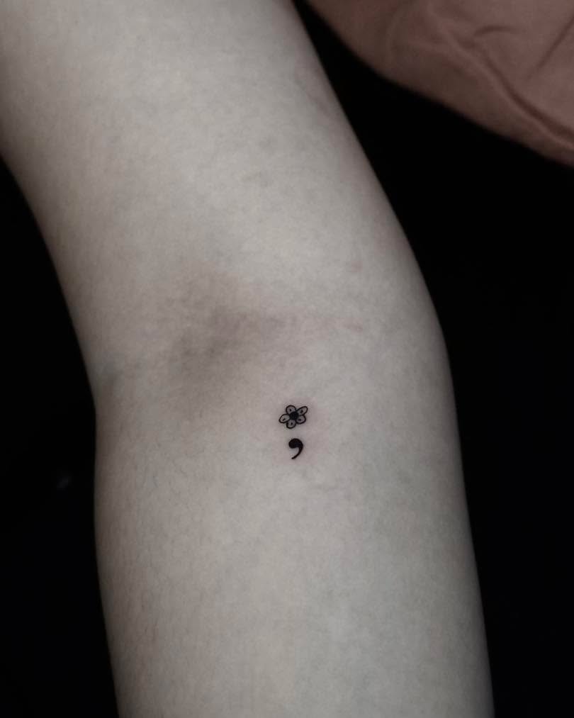 A delicate flower and semicolon tattoo design