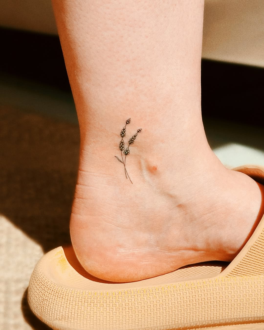 Delicate lavender tattoo on the ankle.