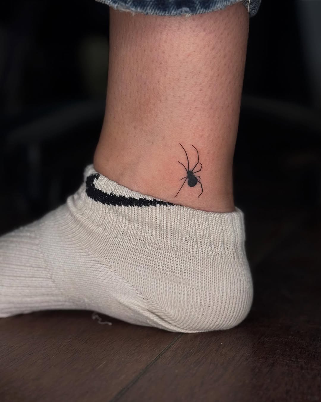 Delicate spider tattoo on the ankle