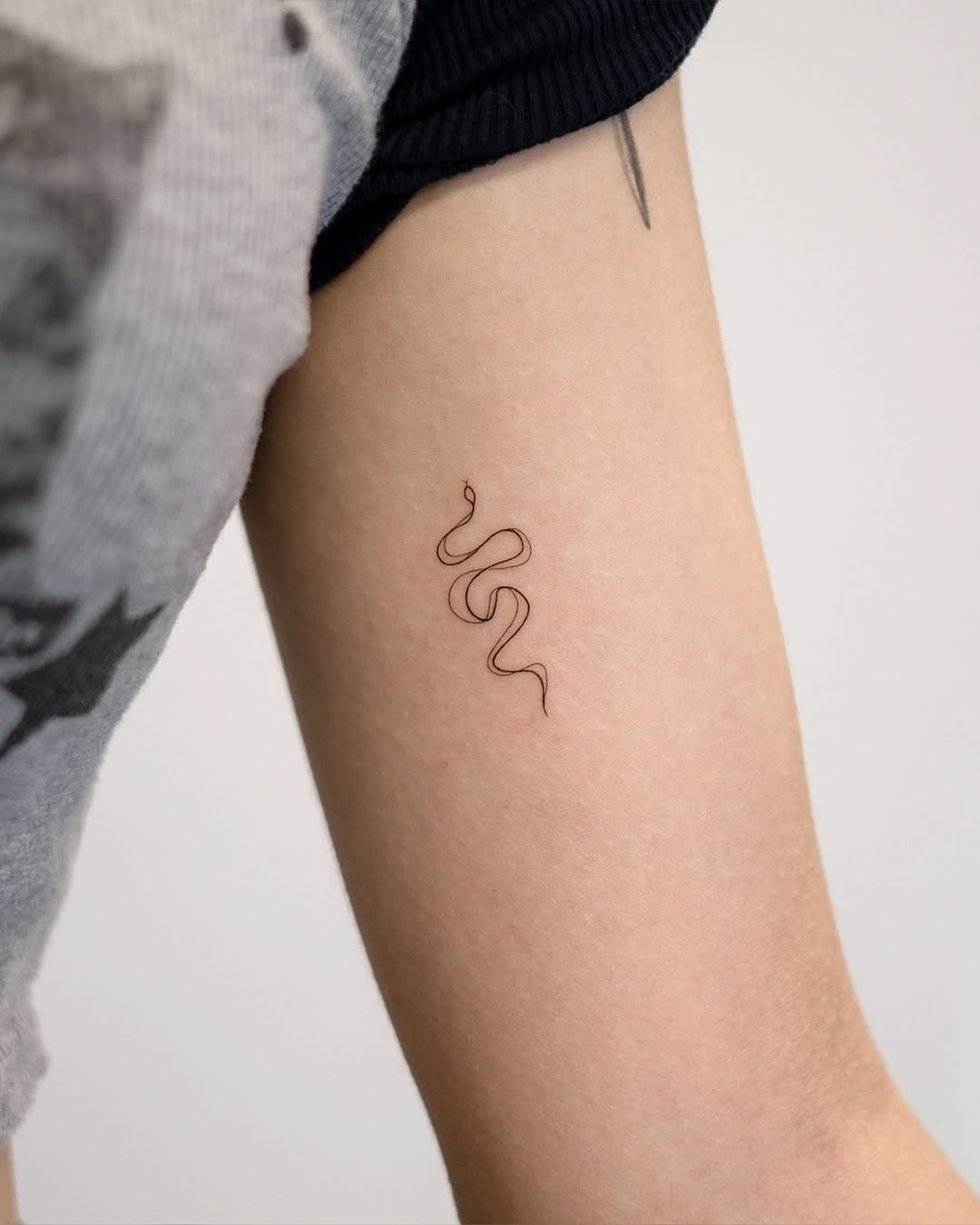 Sleek and simple minimalist snake tattoo