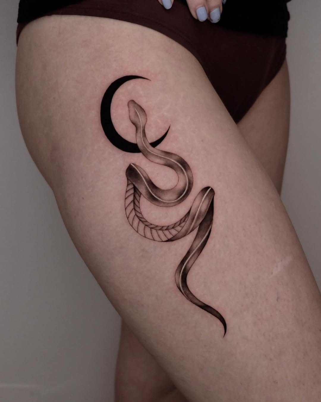 Elegant snake tattoo entwined with a crescent moon