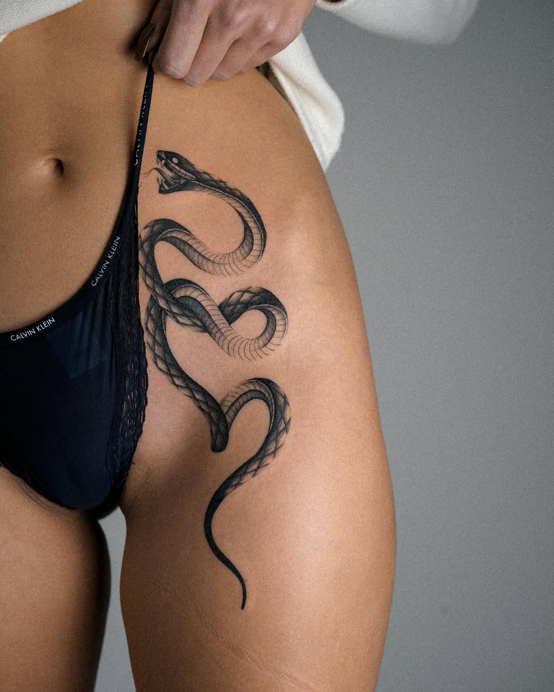 Elegant snake tattoo on thigh for bold expression