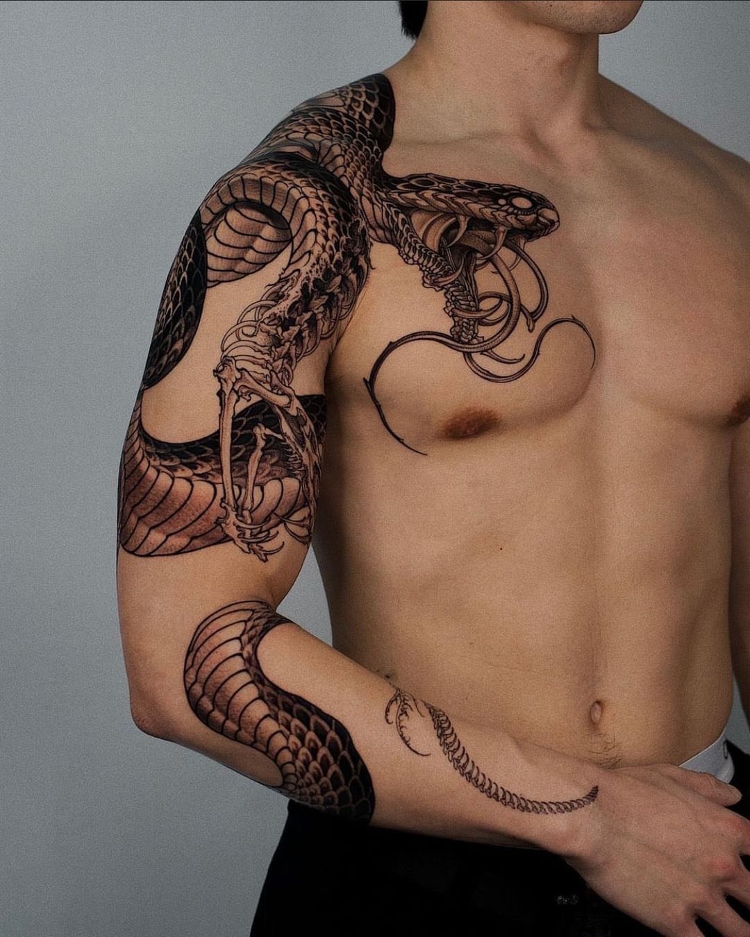 Intricate snake tattoo wrapping around the arm