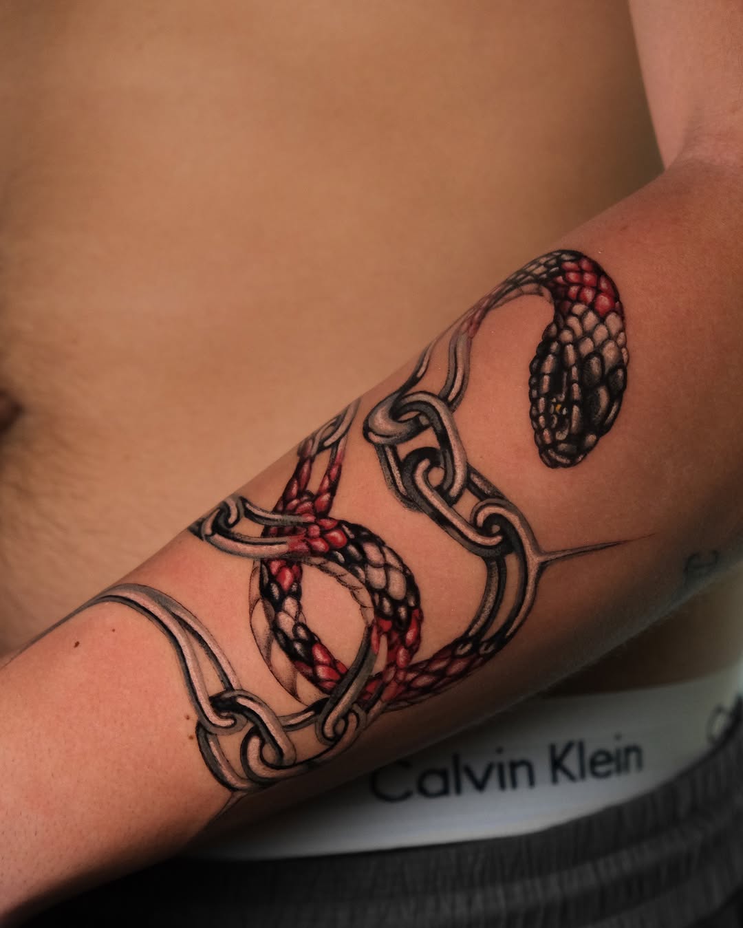 Intricate snake tattoo wrapped around forearm