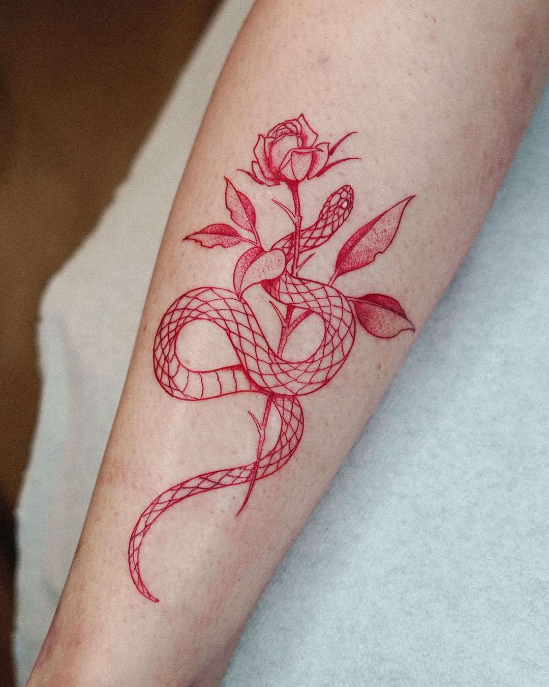 Intricate red snake and rose tattoo art