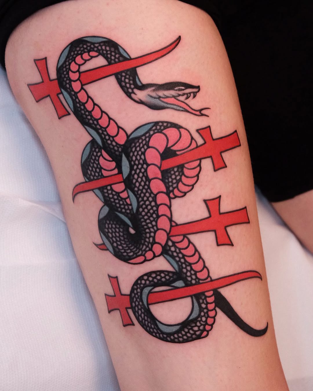 Bold snake tattoo intertwined with crosses