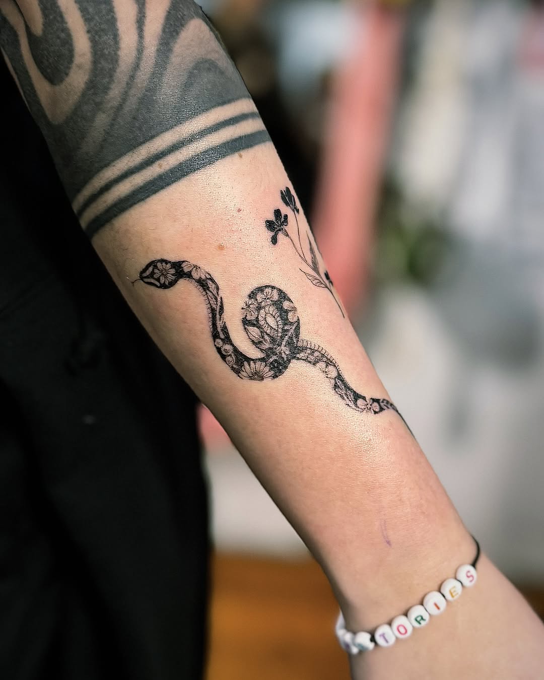 Elegant snake tattoo with floral accents