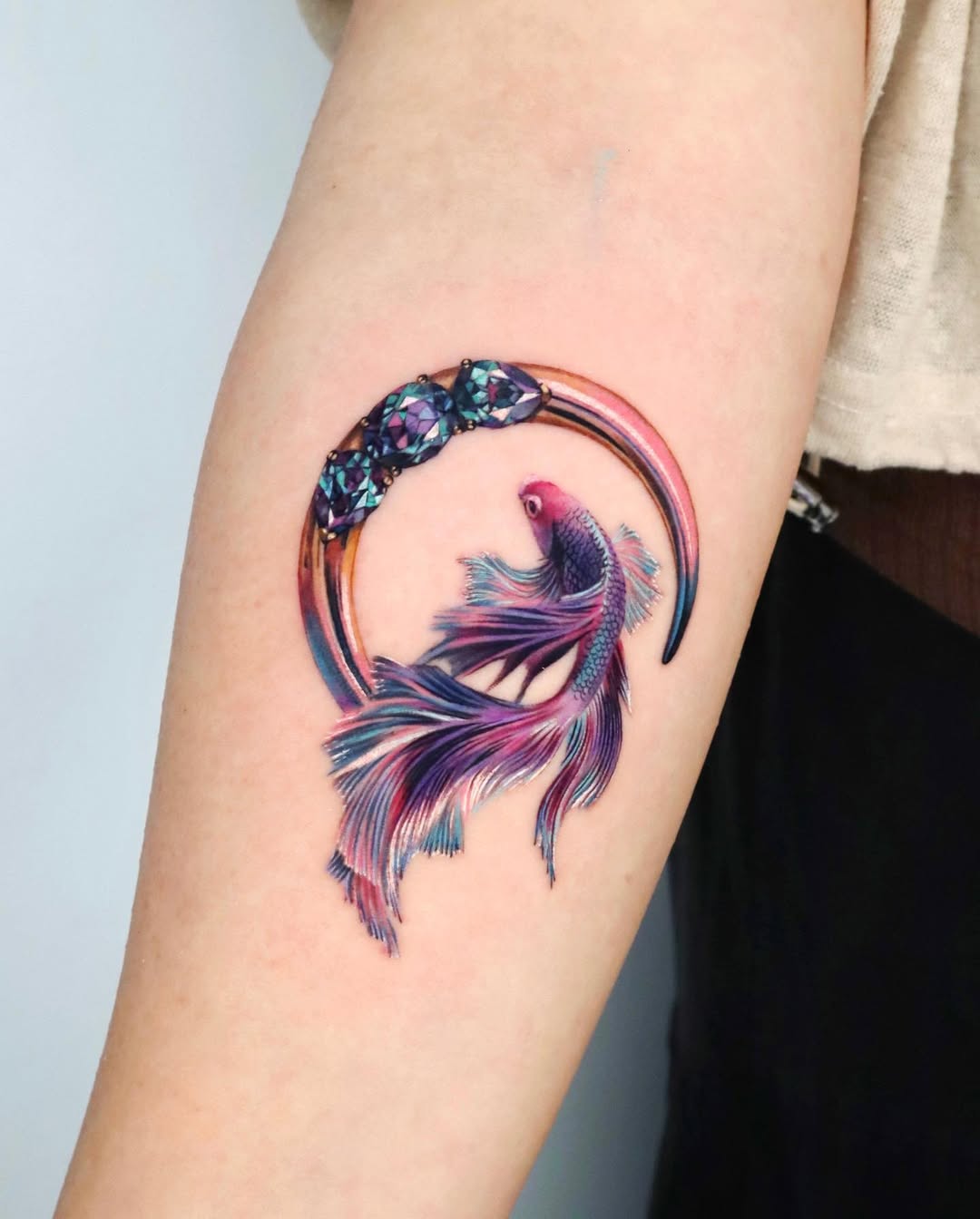 Vibrant fish moon tattoo exudes artistic elegance