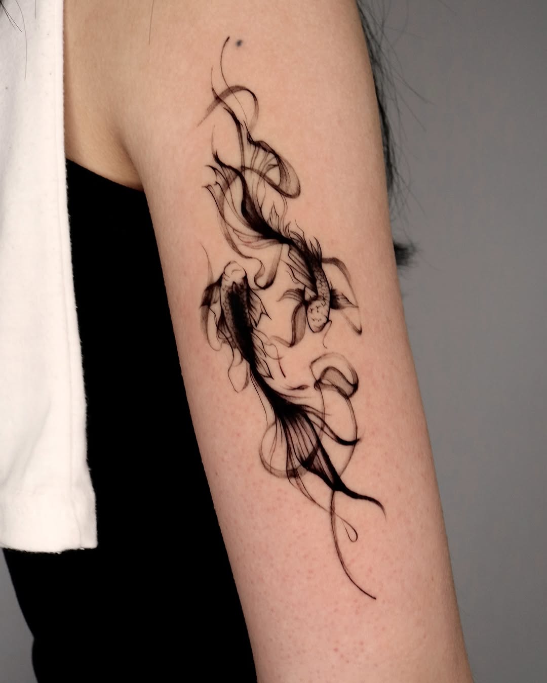 Elegant black ink koi fish tattoo design