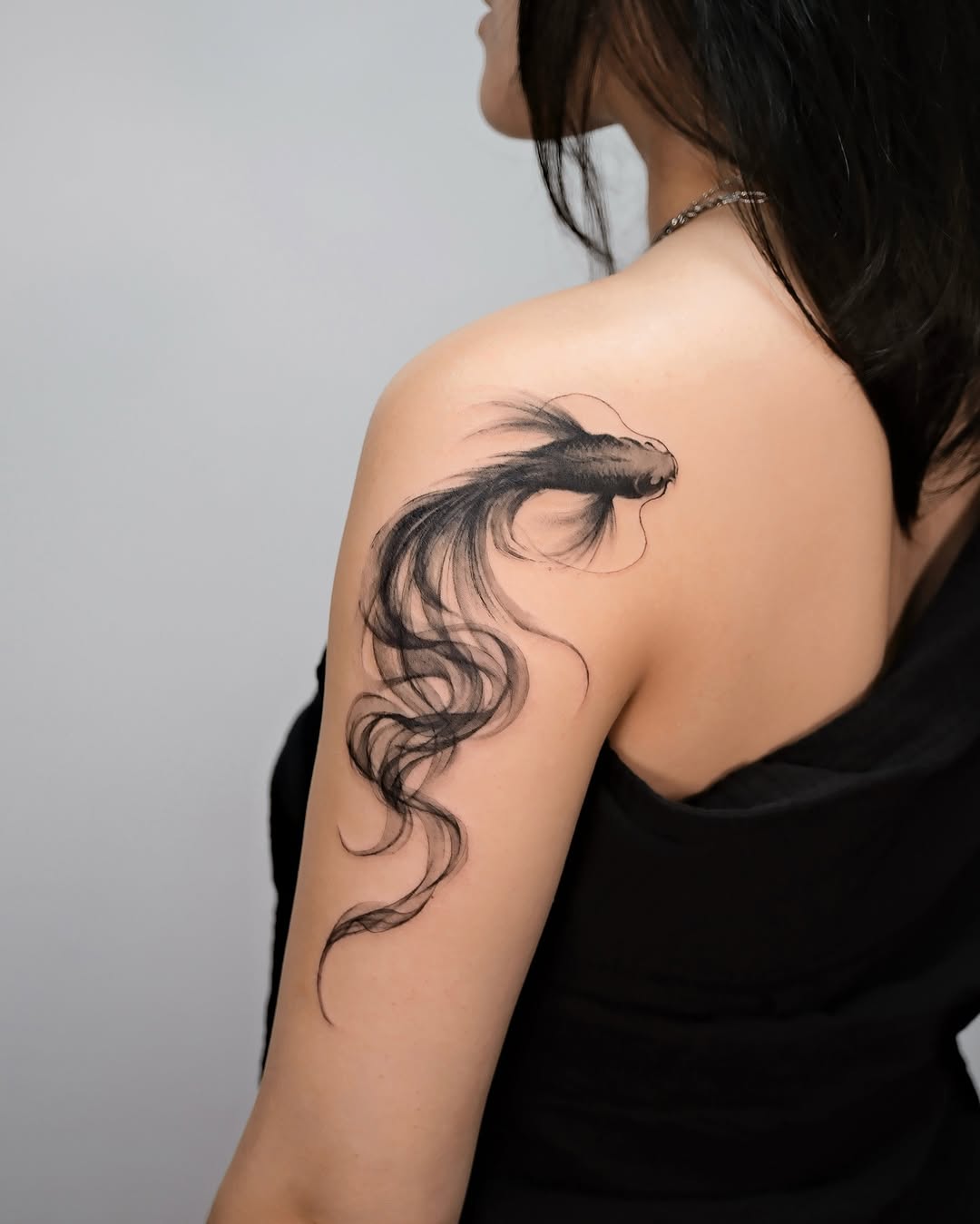 Elegant black ink koi fish tattoo design