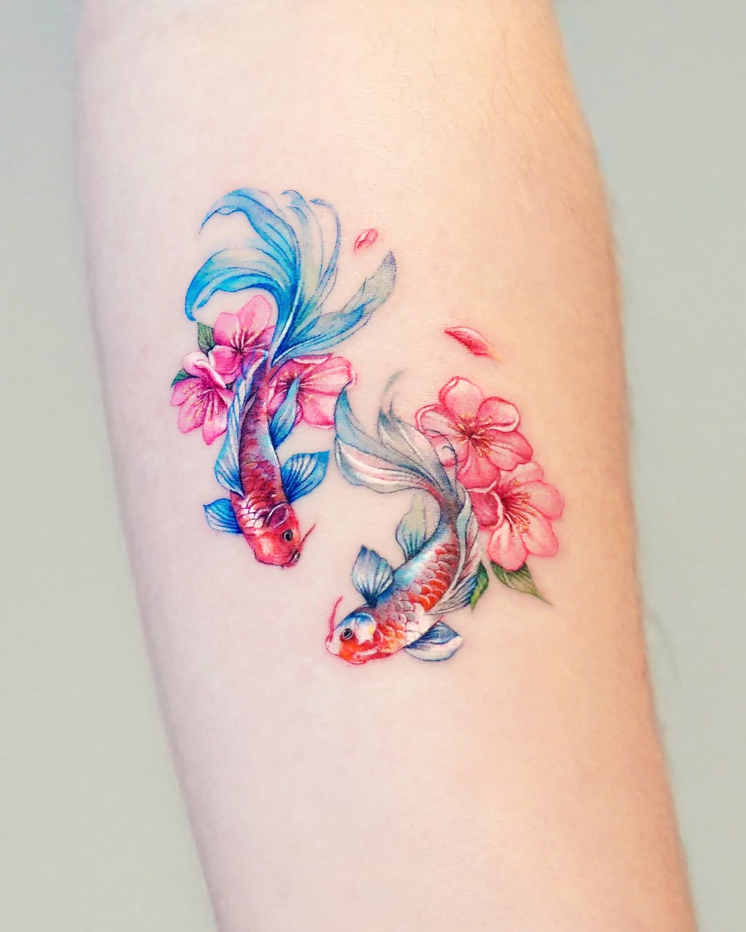 Colorful koi fish tattoo surrounded by flowers