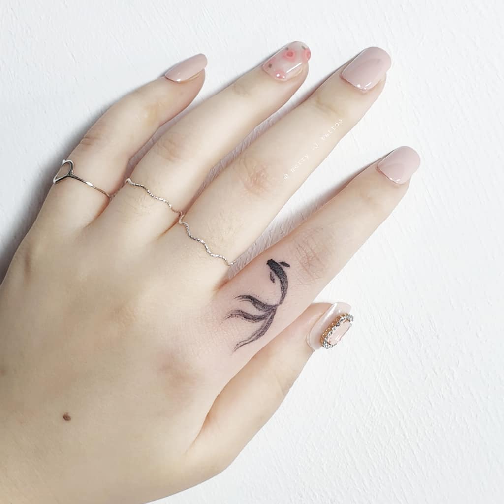 Intricate koi fish tattoo on a hand