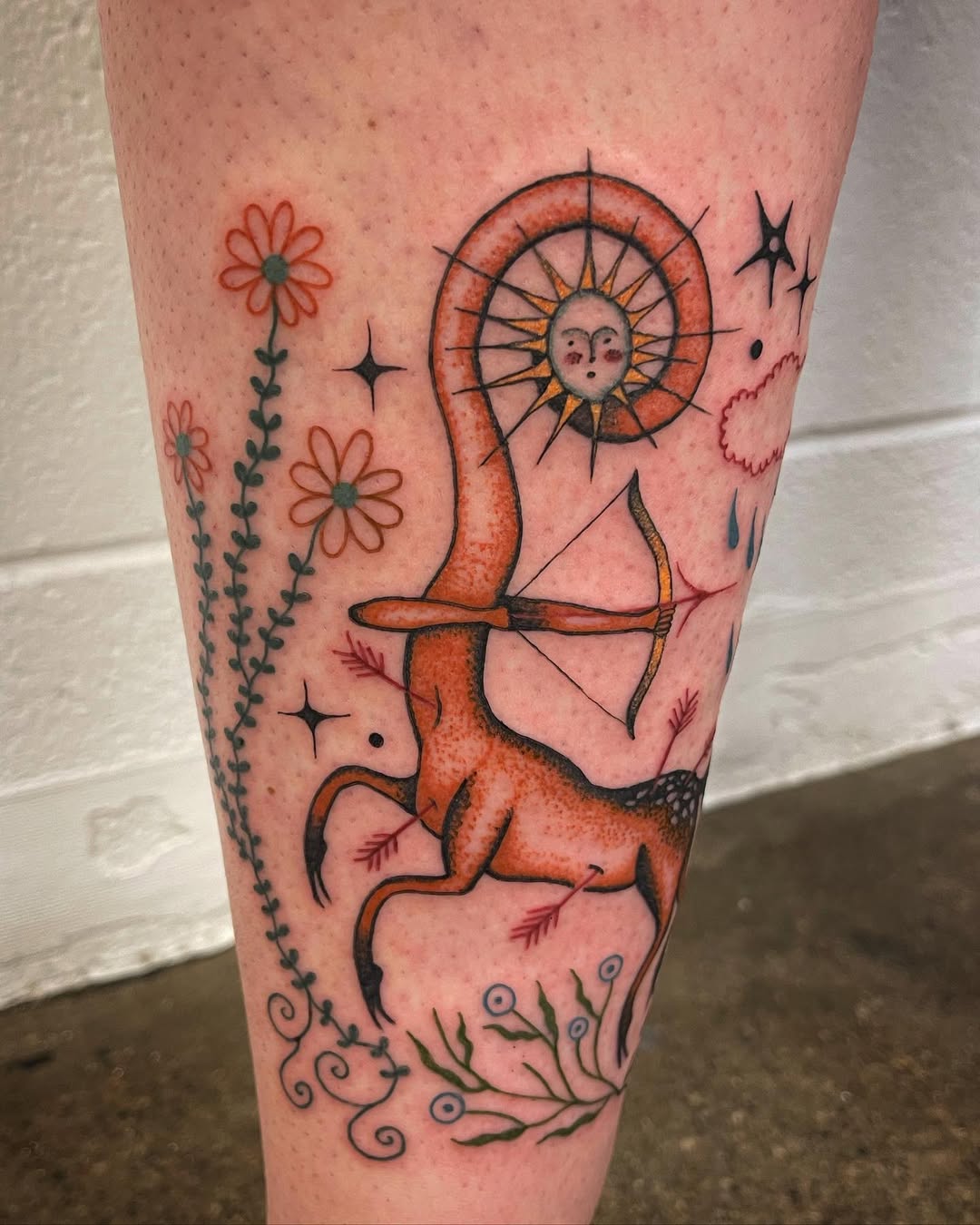 Whimsical Sagittarius tattoo with floral elements