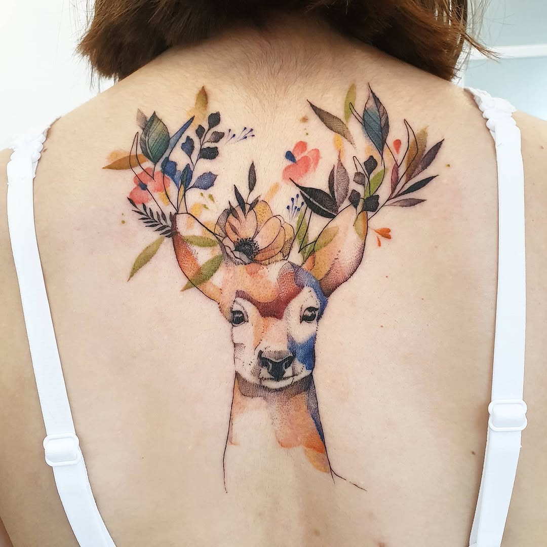 Vibrant watercolor deer tattoo with floral accents
