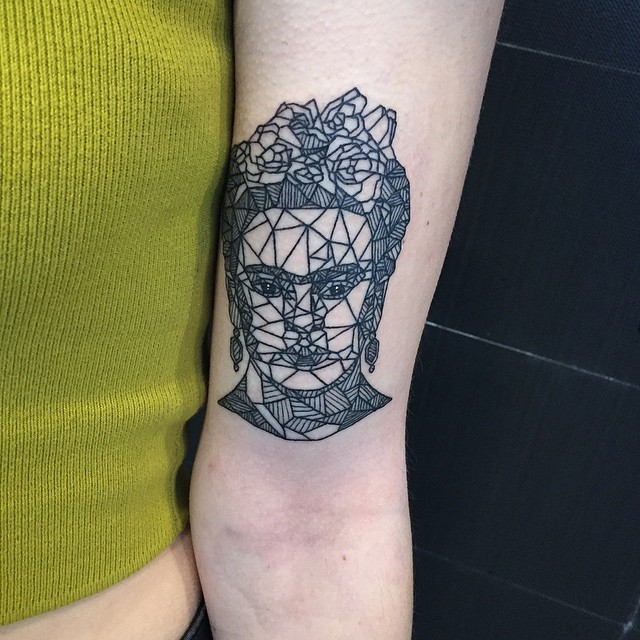 Geometric Frida Kahlo tattoo with floral accents