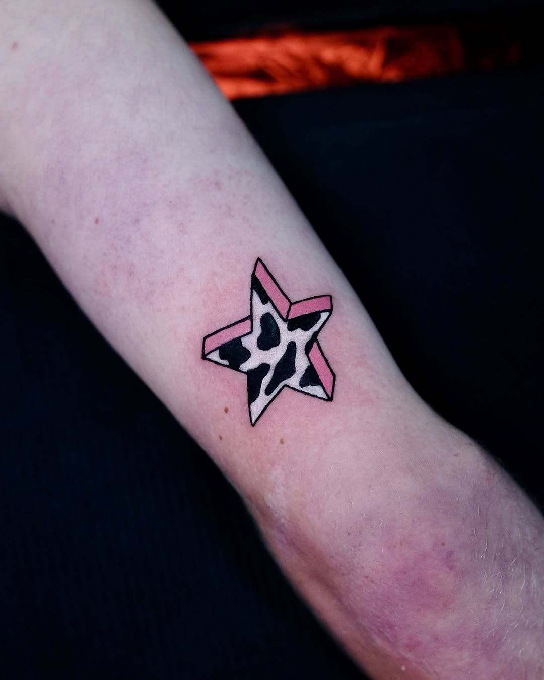 Bold star tattoo with playful patterns and colors