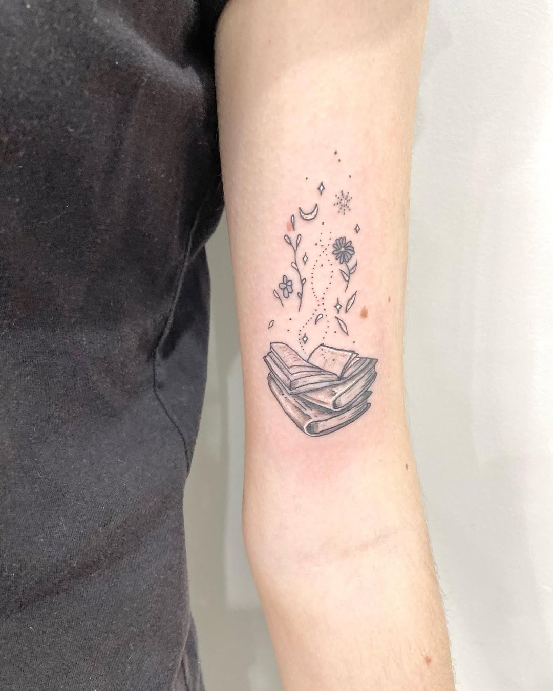 Delicate Book Tattoo with Floral Elements